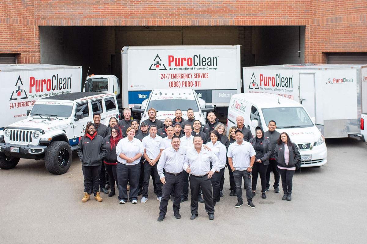 group of PuroClean team outside with their company vehicles