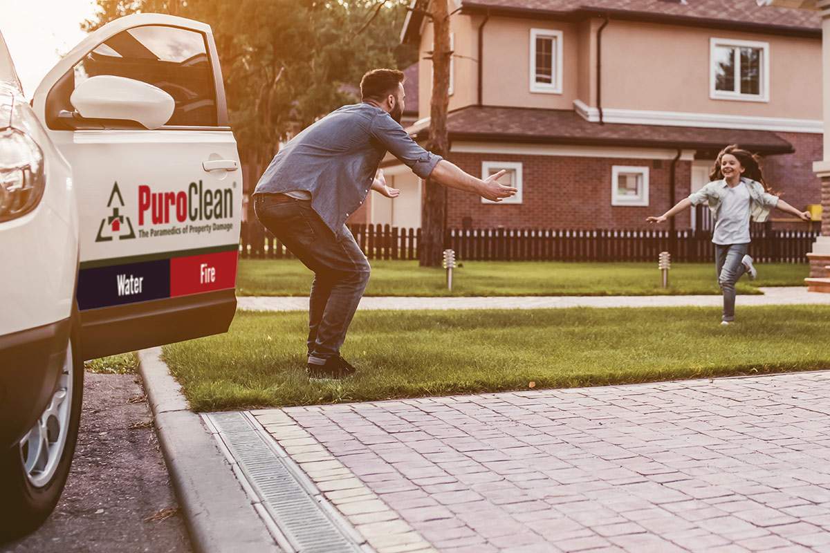 PuroClean trunk open with man arms open for child