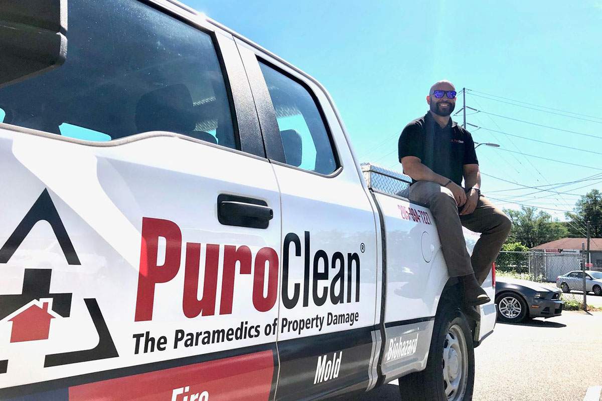 PuroClean truck with partner sitting on it