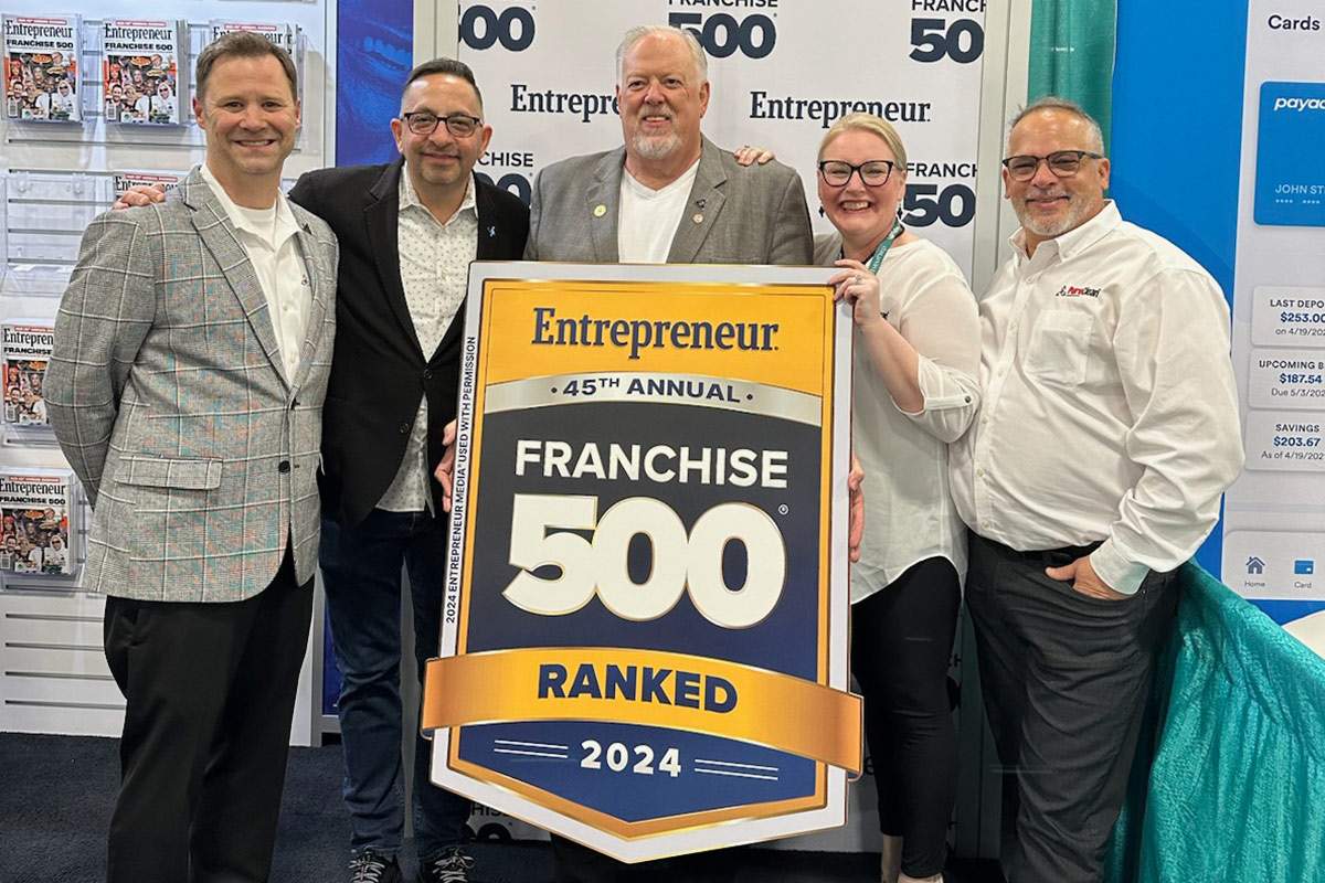 five men standing with a franchise 500 sign