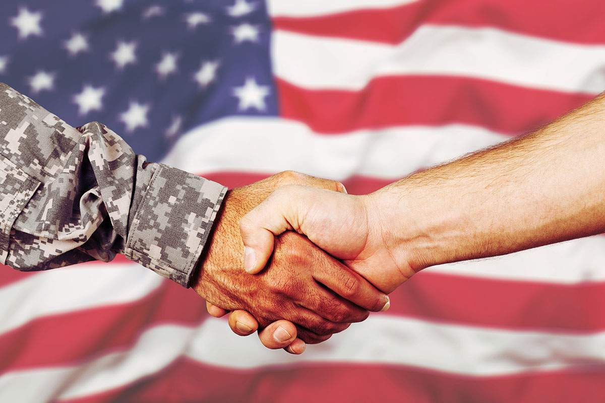 Two men shaking hands, one in military uniform