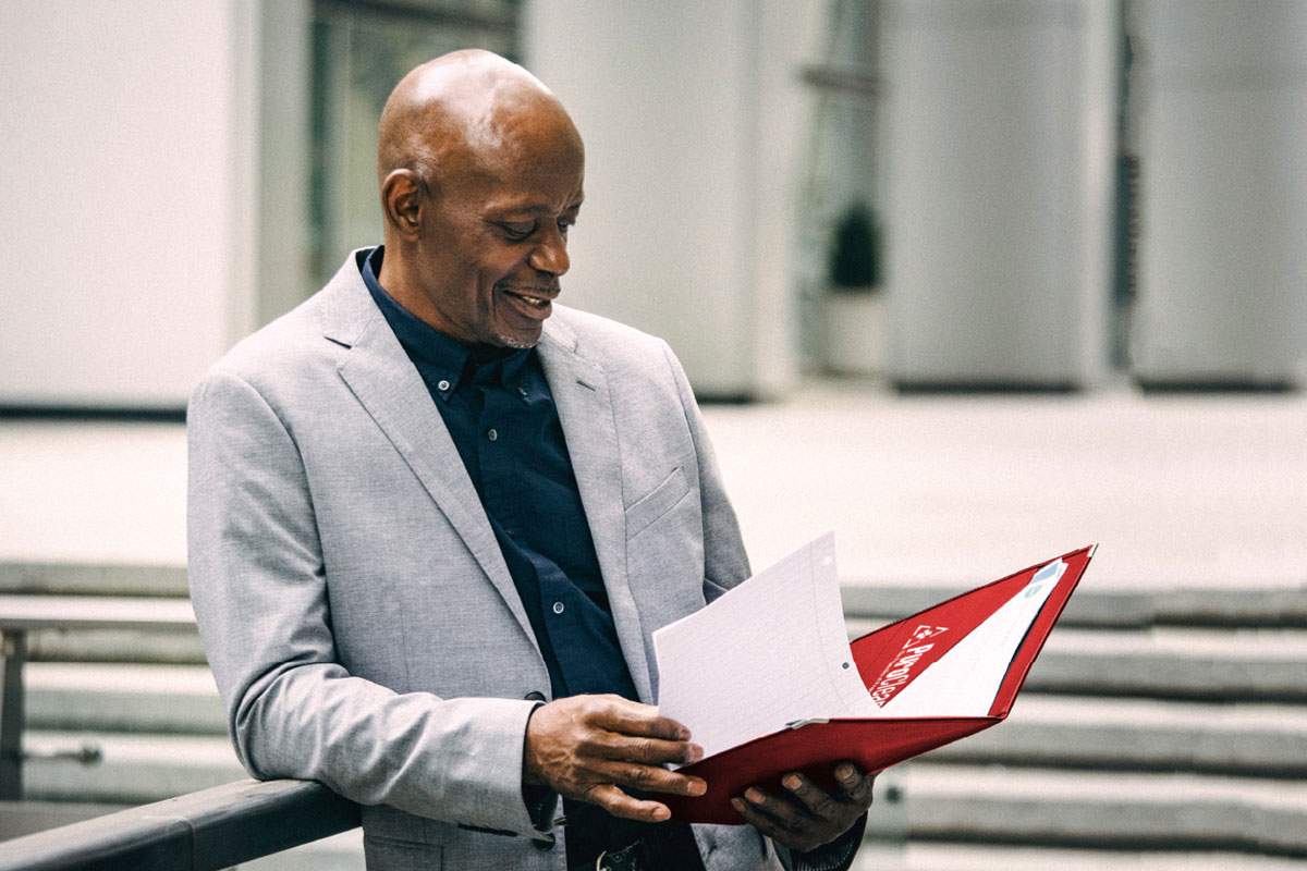 man in blazer looking at a folder