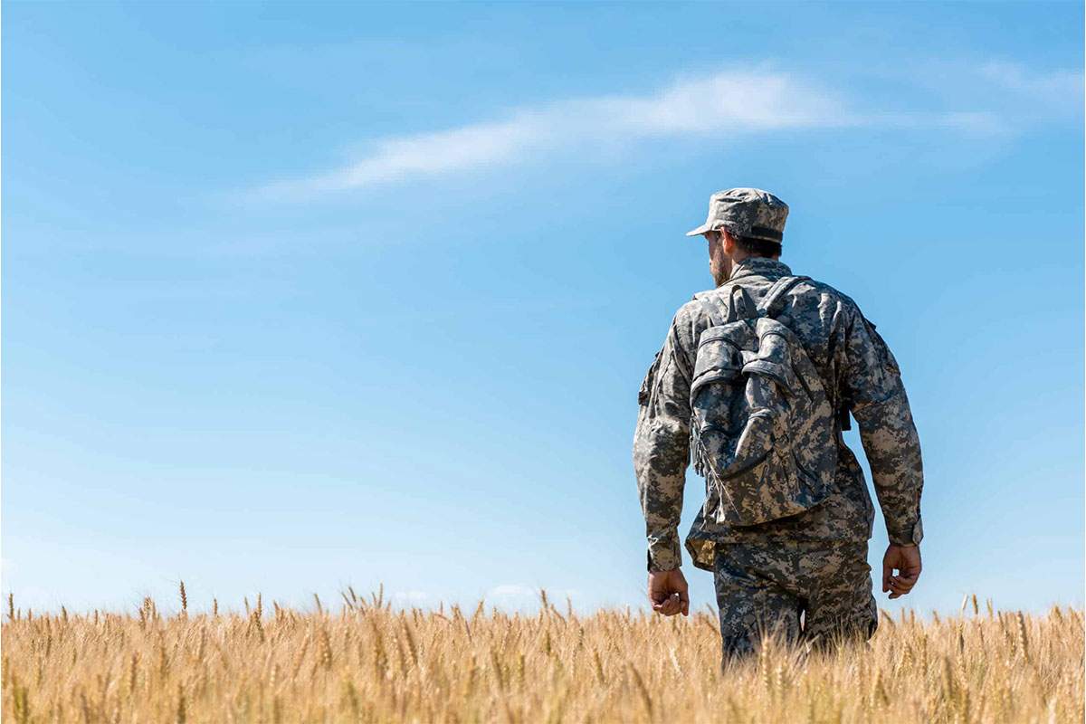 Military veteran walking through a field - featured image for an article about how PuroVet is empowering veterans