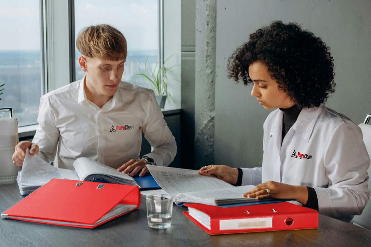 PuroClean employees looking at guides at a desk