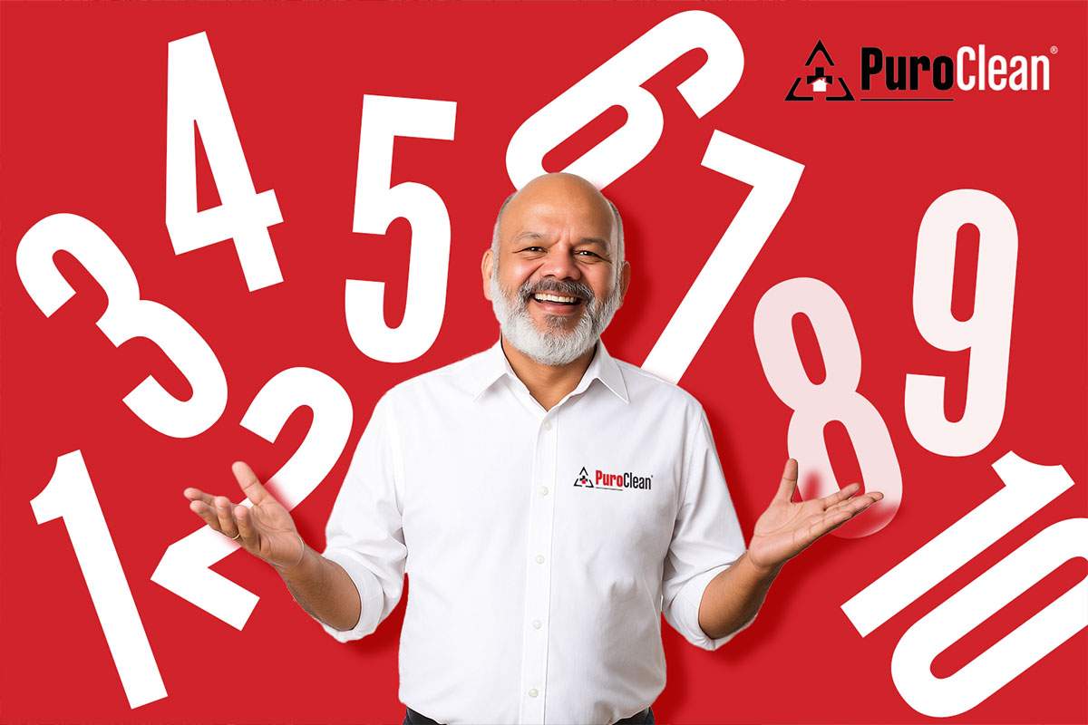 man in PuroClean shirt with a red background and white numbers