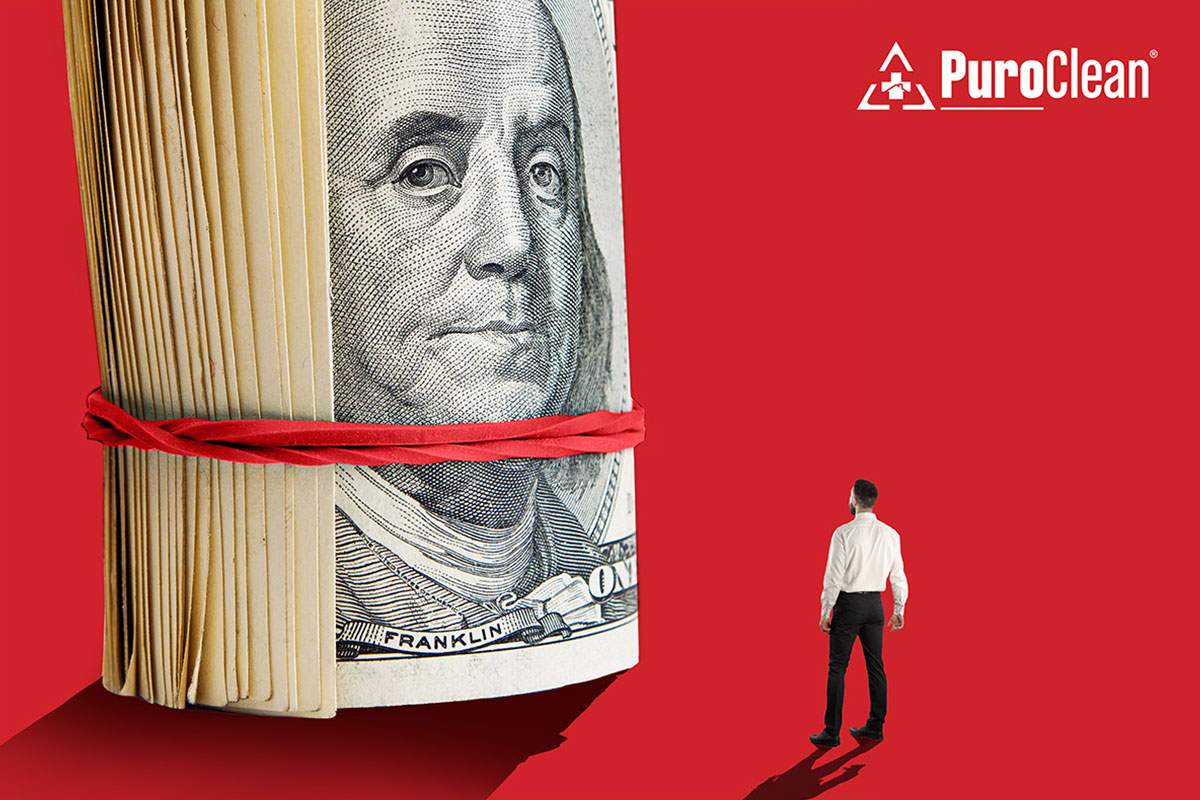 man standing in front of larger than life cash