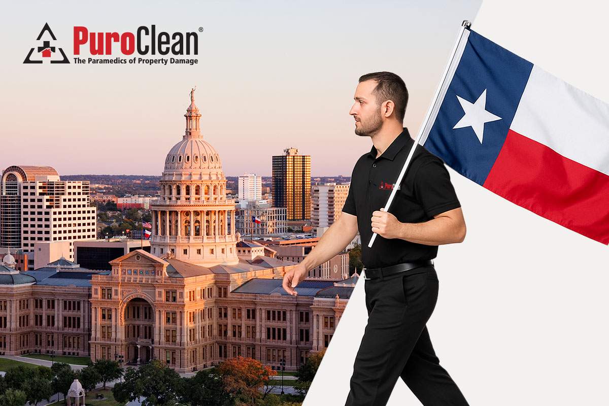 man walking with Texas flag with buildings in the back