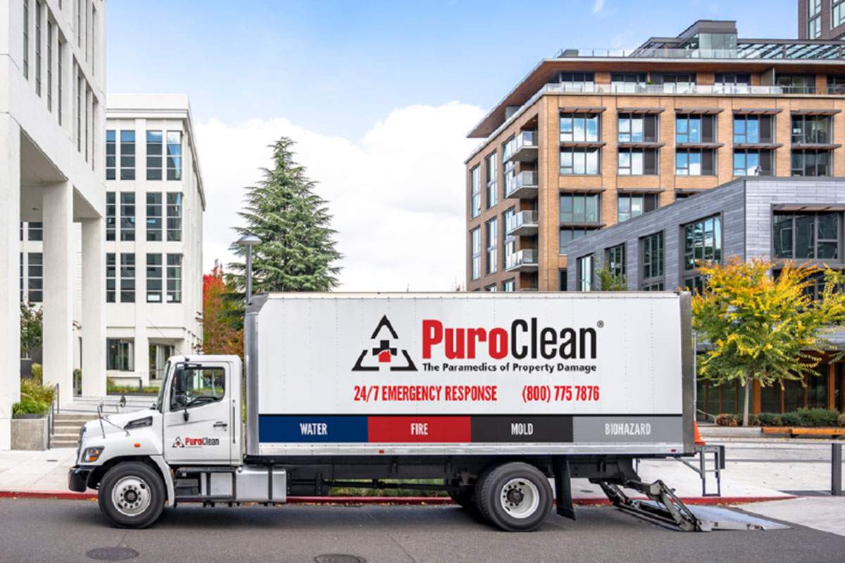 PuroClean box truck surrounded by tall buildings