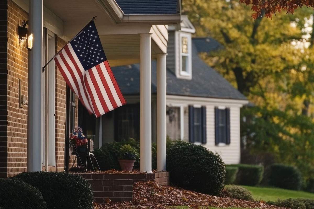 front patio of brick home decorated with american flag